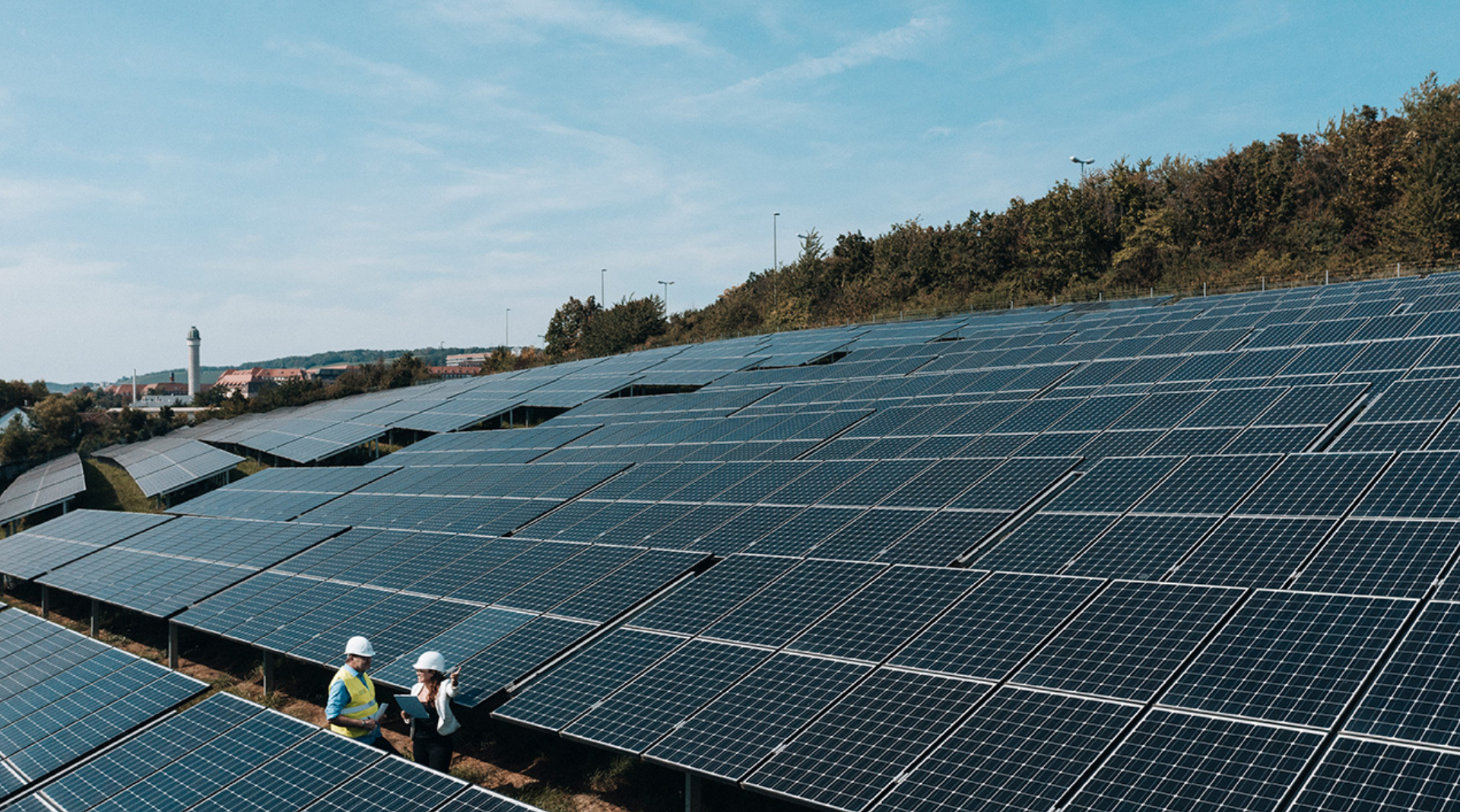 Zwei Männer in Arbeitsklamotten stehen in einem Solarpark in Würzburg | SENS